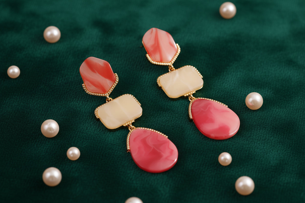 Pair of earrings with pink and beige stones on a beige background