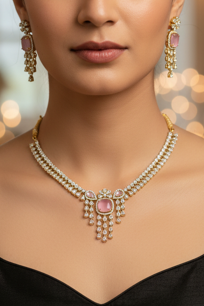 A silver-toned jewelry set featuring a necklace and matching earrings with pink stones and clear rhinestone embellishments, displayed on a white jewelry bust.