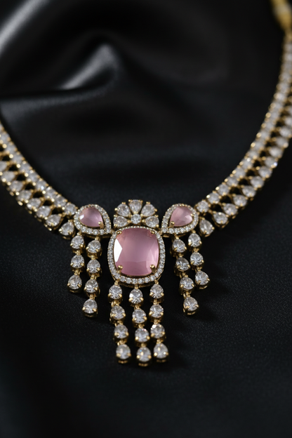 A silver-toned jewelry set featuring a necklace and matching earrings with pink stones and clear rhinestone embellishments, displayed on a white jewelry bust.