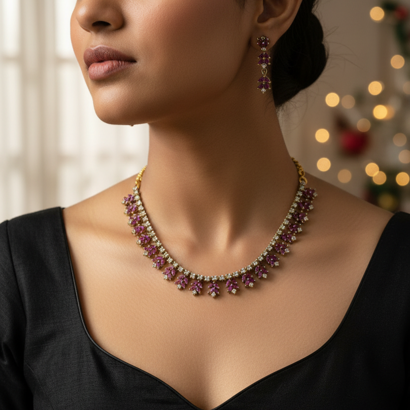 Gold-plated jewelry set featuring a necklace and matching drop earrings with deep purple gemstone floral motifs, displayed on a textured white jewelry bust.