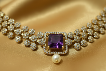Luxury diamond necklace with a central purple gemstone on a gold fabric background